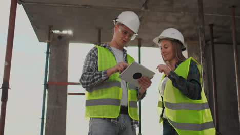 ingenieros o arquitectos tienen una discusión en el sitio de construcción mirando a través del plan de construcción. contre jour. ingenieros o arquitectes tienen una discusion