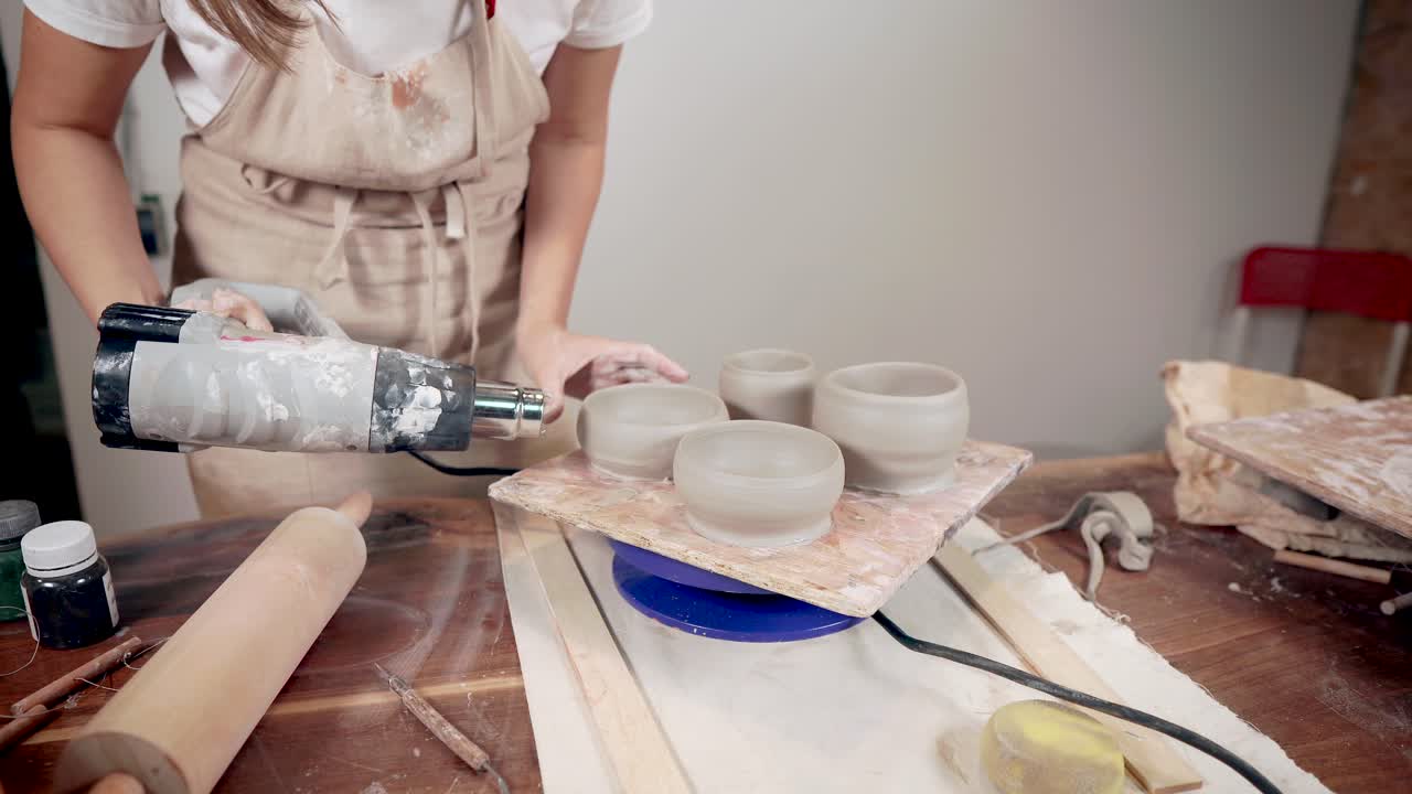 mujer disparando cuencos de cerámica