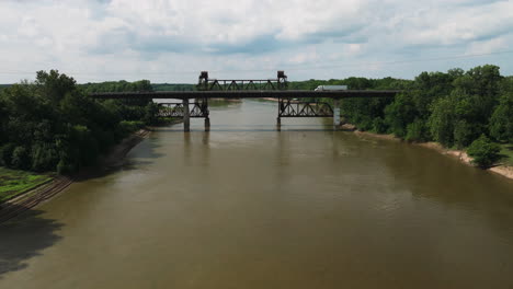 truck driving on highway bridge next to old rusted railroad bridge crossing white river in de valls bluff, arkansas