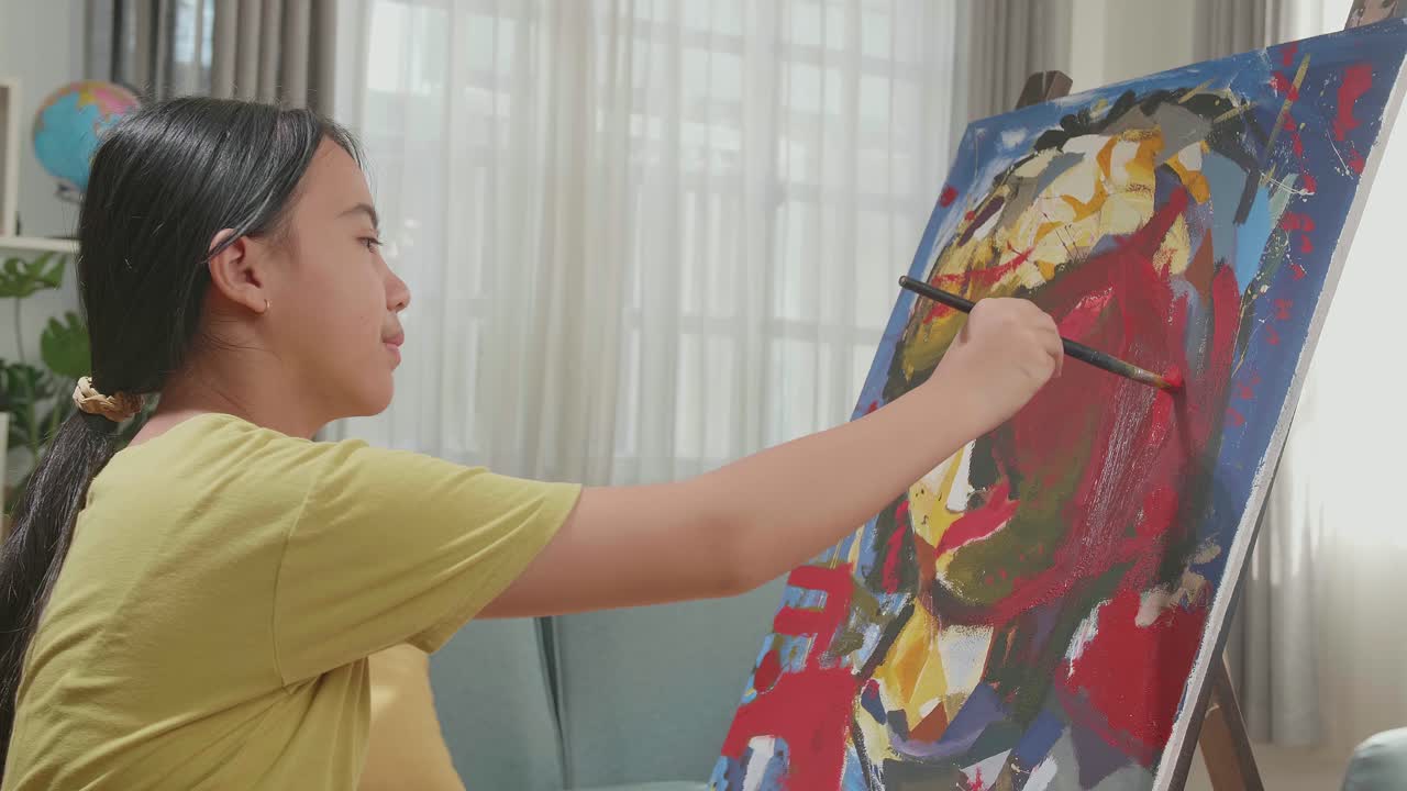 Medium Shot Side View Of An Asian Artist Girl Holding Paintbrush Mixed Colour And Painting A Girl'S Ear On The Canvas