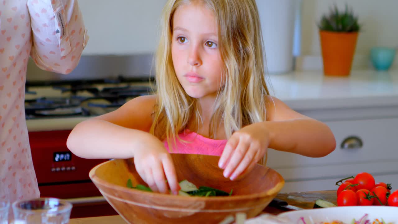 Ragazza che prepara l'insalata in cucina 4k