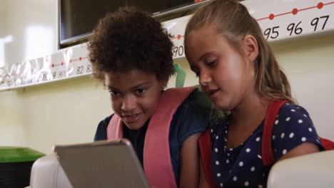 two girls using digital tablet in the class