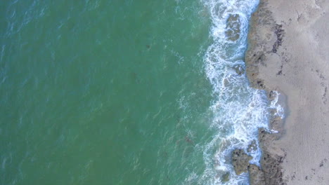 A-straight-down-shot-of-surf-crashing-onto-the-beach