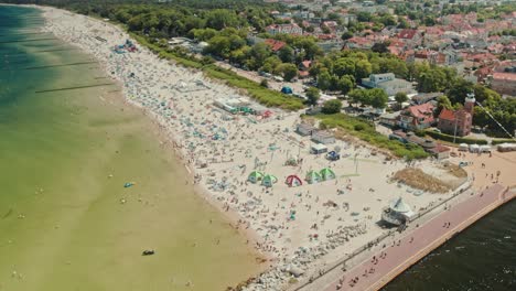 playa soleada llena de turistas bañándose vista desde un avión no tripulado