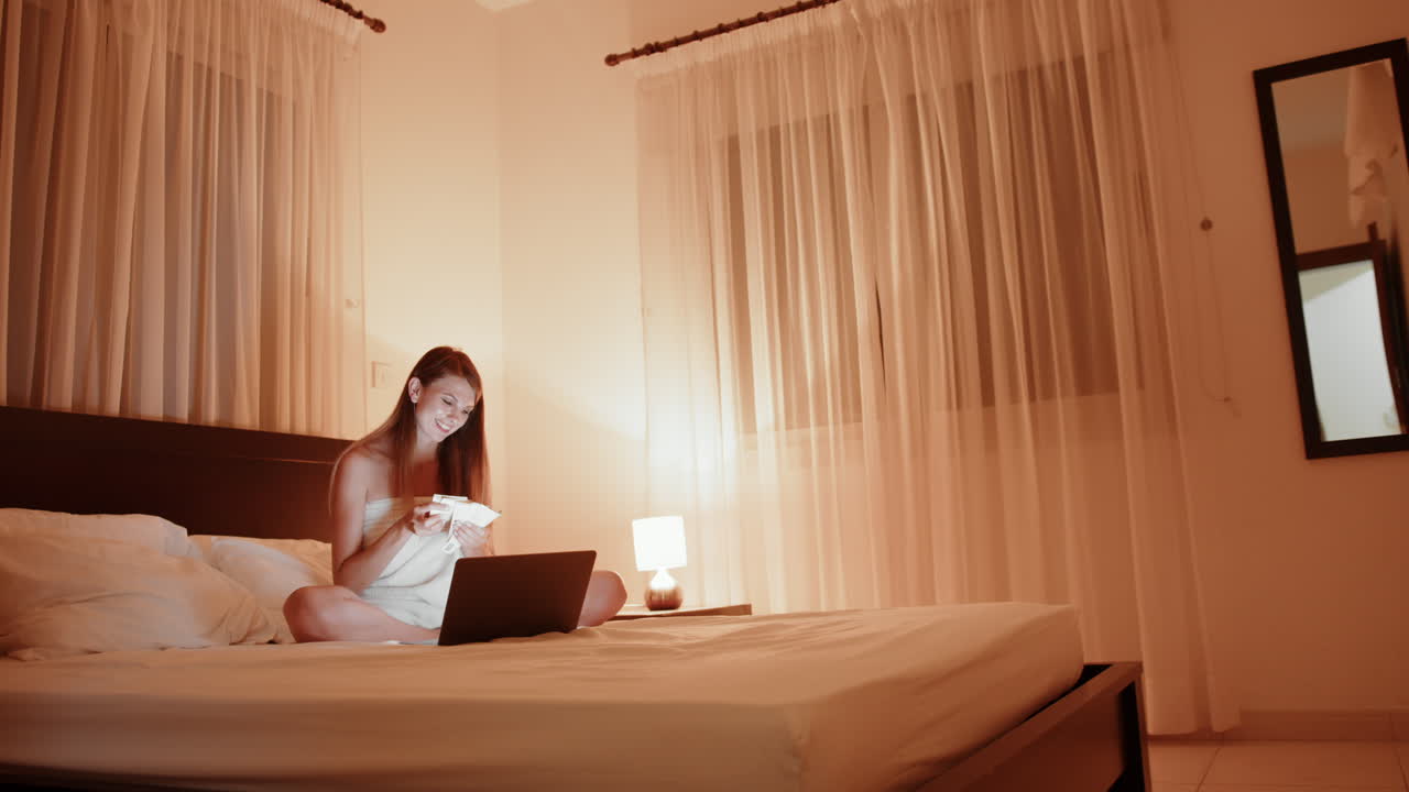 밤에 침대에서 노트북으로 일하는 여자