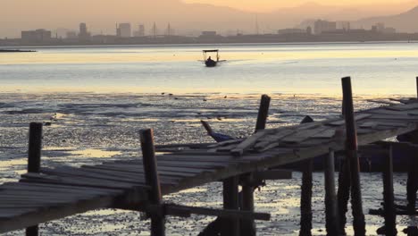 Barco-De-Pesca-Se-Mueve-En-El-Mar-Cerca-Del-Puente-De-Madera