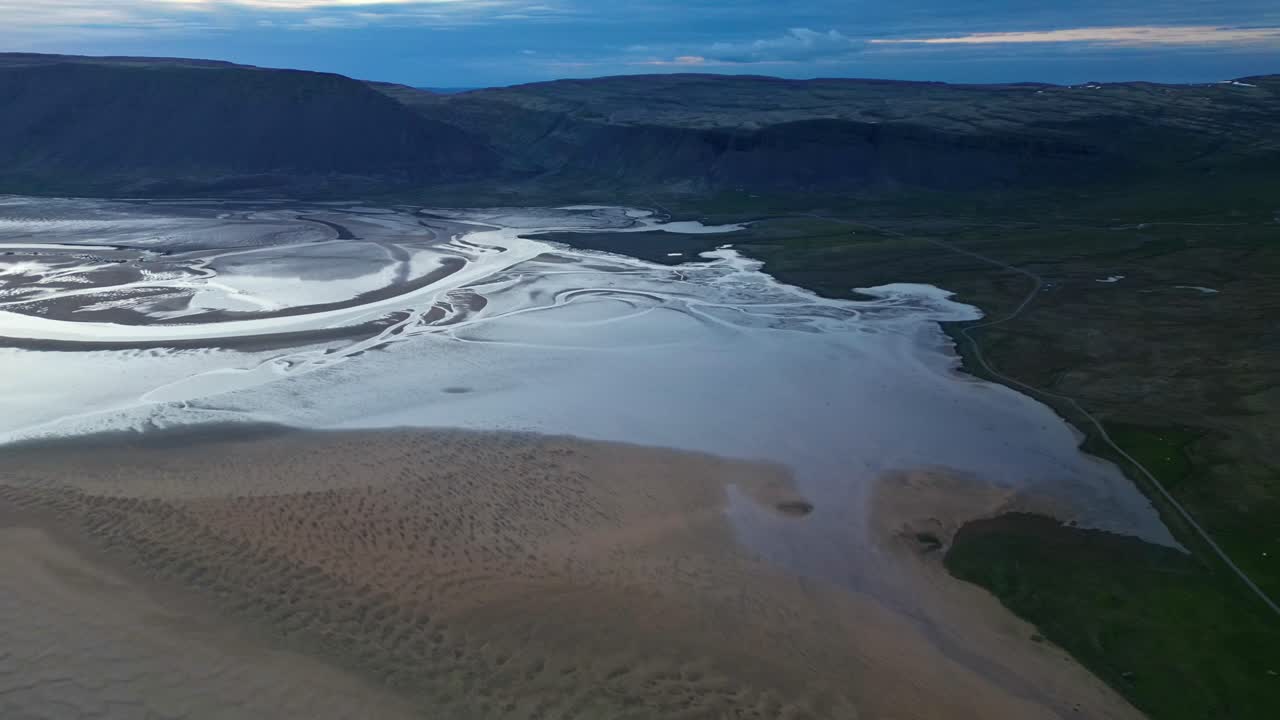 Splendidi filmati aerei di fiumi glaciali intrecciati e motivi di sabbia in una valle islandese durante l'ora blu. Ideale per documentari naturalistici e contenuti di viaggio. Raudisandur, Islanda