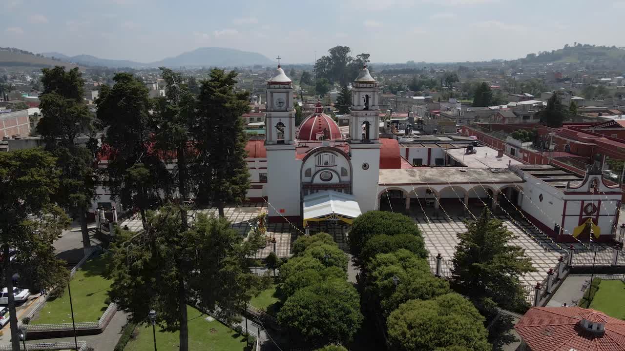 Ripresa aerea orbitante di una chiesa con montagne sullo sfondo a Mazamitla, Jalisco, Messico.