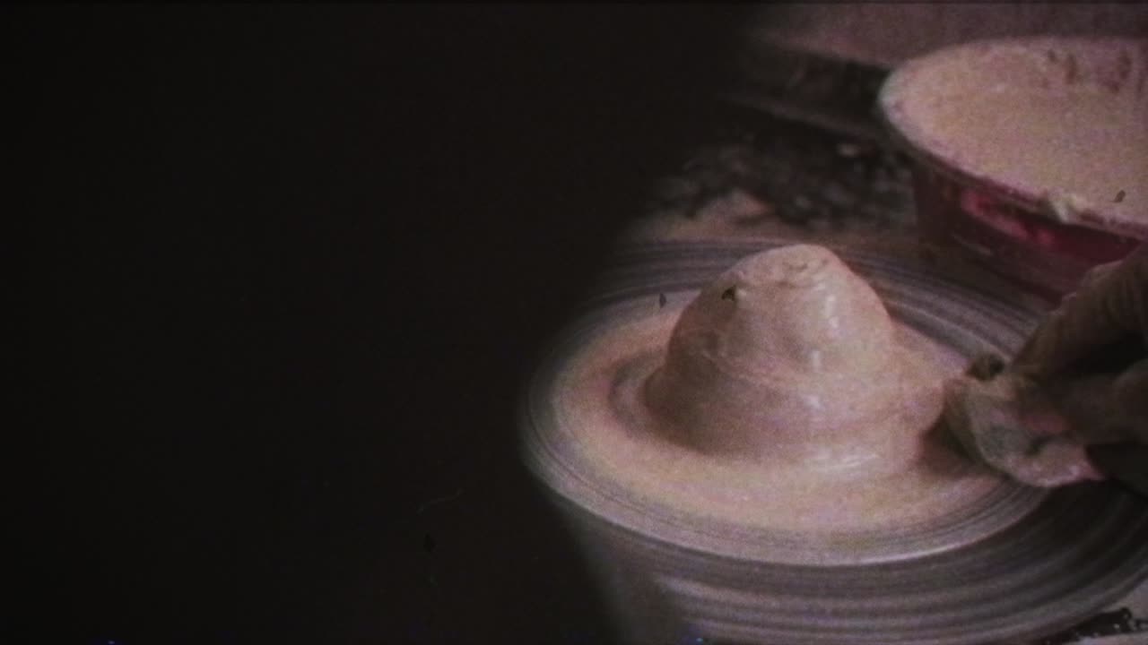 un alfarero enseña a una mujer a hacer platos de arcilla. un hombre toma las manos de una mujer. efecto vintage.