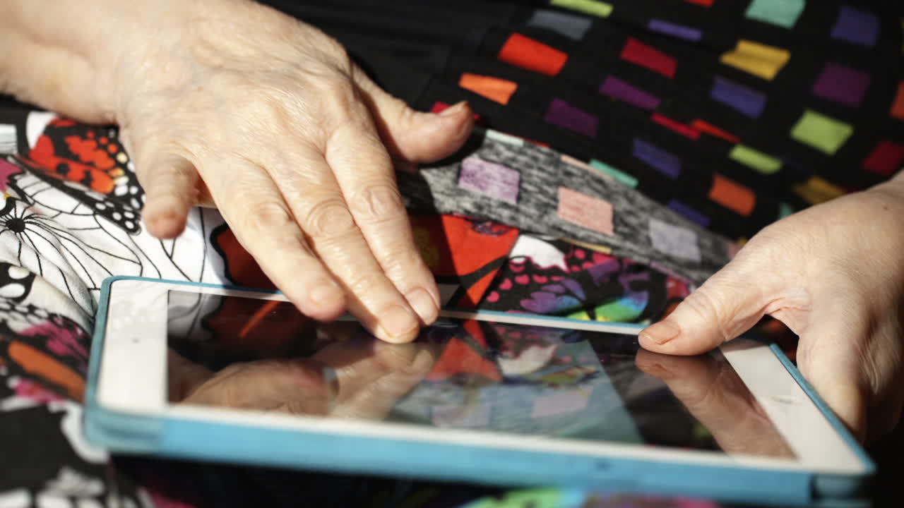 mujer anciana desplazando lentamente fotos en el touchpad