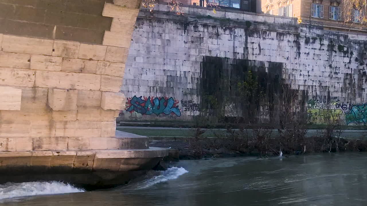 Close up view of ancient bridge and river Tiber in Isola Tiberina on a sunny day