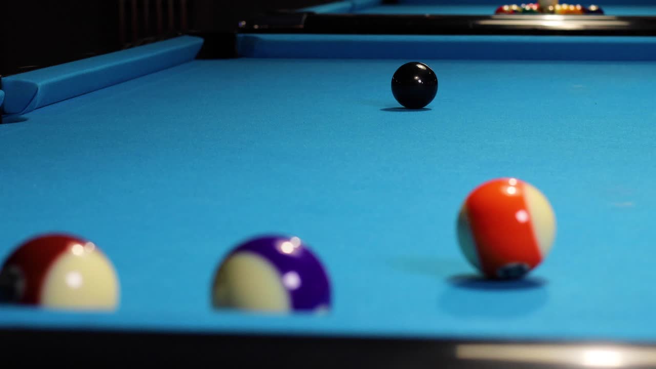 Playing a game of pool billiards hitting the black ball