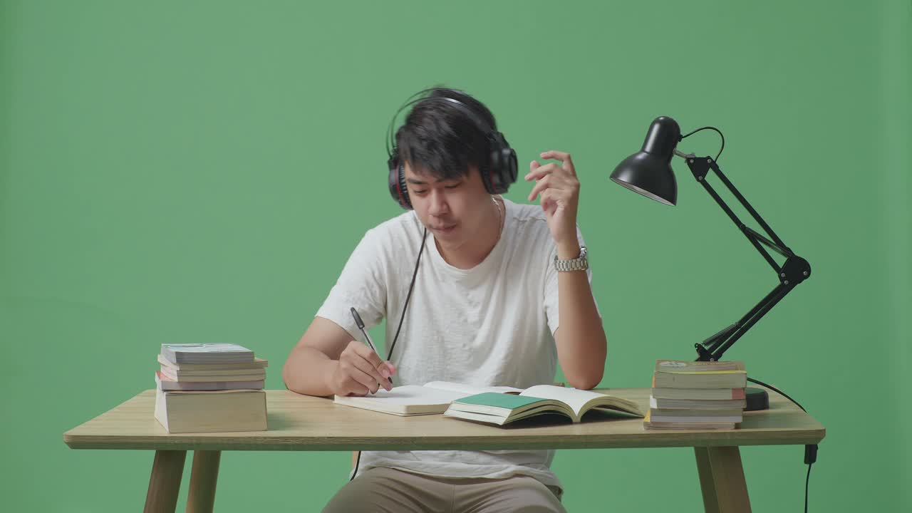 헤드폰을 들고 공부하는 학생