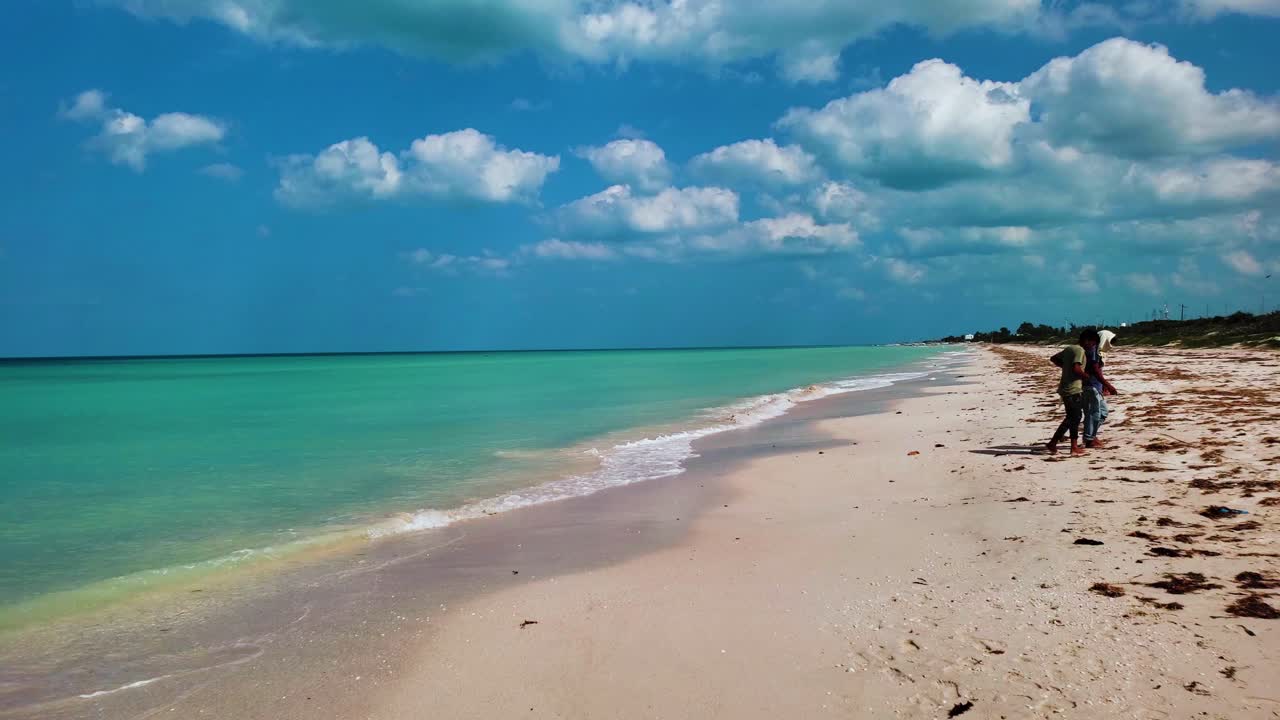 Tropical Cuba seashore with tourists walking on the beach, turquoise water and cloudy sky, Cuba travel destination, Slow motion panning