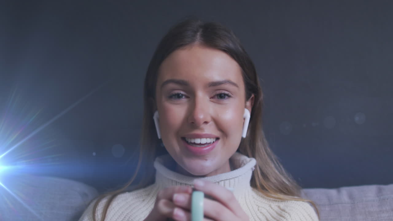 Animazione di punti luce su una donna caucasica sorridente che beve caffè e fa una videochiamata a casa