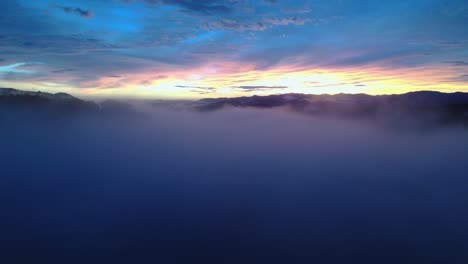 Drohnenflug-Durch-Malerische-Blaue-Sonnenuntergangswolkenlandschaft-Mit-Leuchtend-Buntem-Horizont,-4k