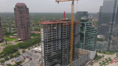 Aerial-shot-of-skyscraper-building-under-construction-with-crane-in-downtown-Houston,-Texas,-USA