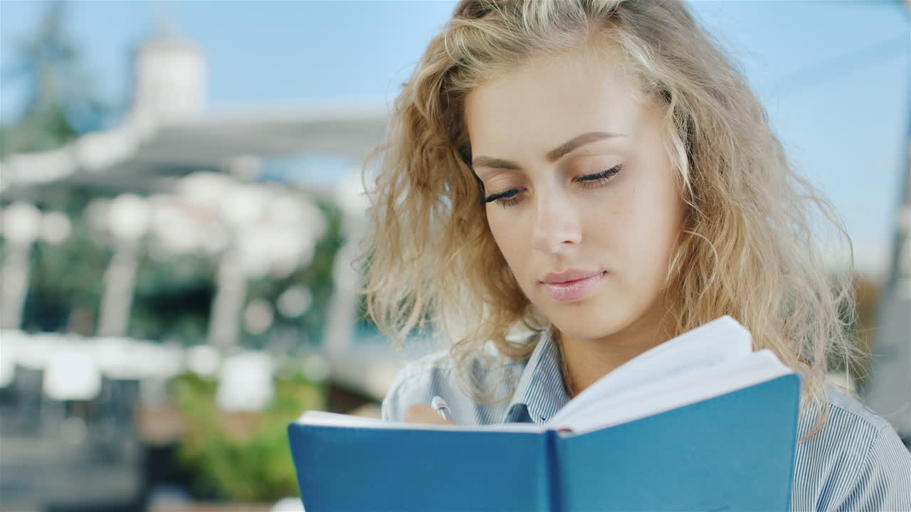 Portrait Of Attractive Young Woman Writes In A Notebook He Dreams Smiles Positive Emotions