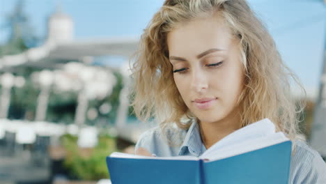 retrato de mujer joven atractiva escribe en un cuaderno que sueña sonríe emociones positivas