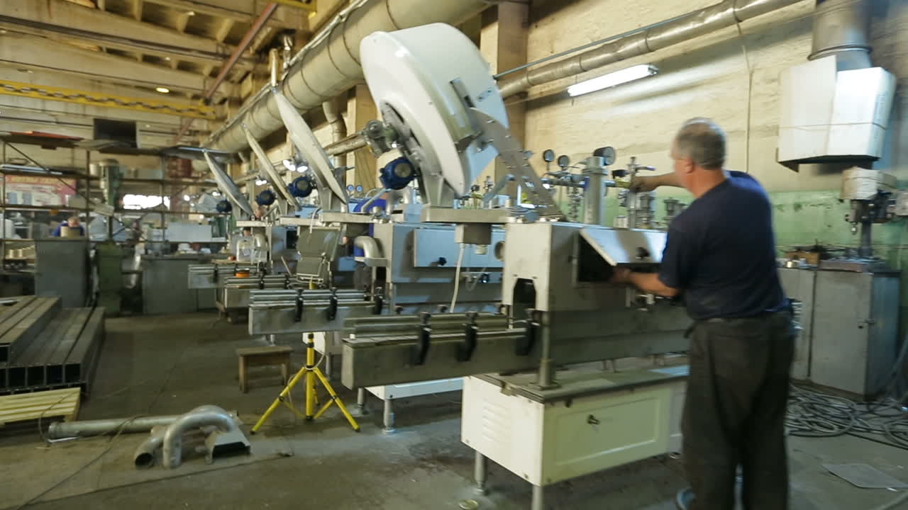 Man Working With Machines. BAR, UKRAINE - AUGUST 2017: Mechanical engineering control machine in factory