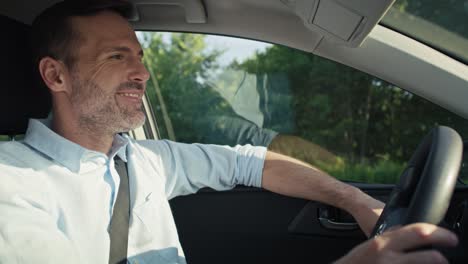 caucasian man of middle age driving a car.