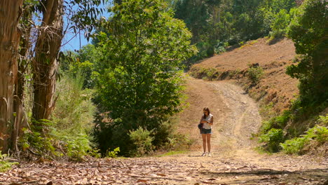 Hermosa-Chica-Revisando-Gps-En-Un-Sendero-En-Medio-Del-Bosque