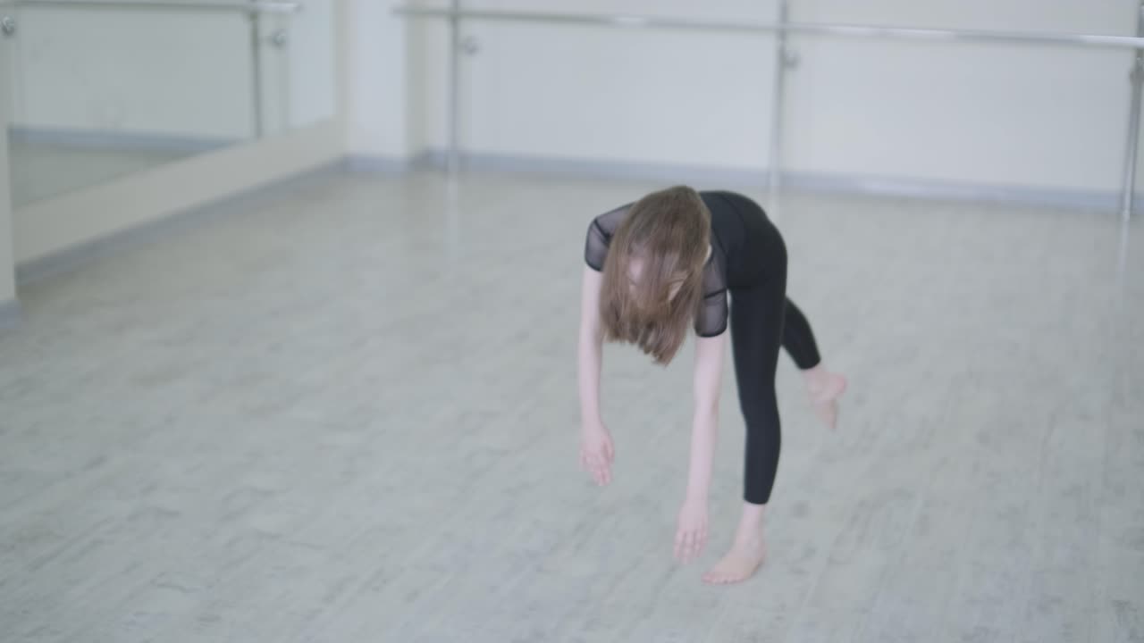 젊은 발레리나 가 스튜디오 에서 춤 을 연습 하고 있다