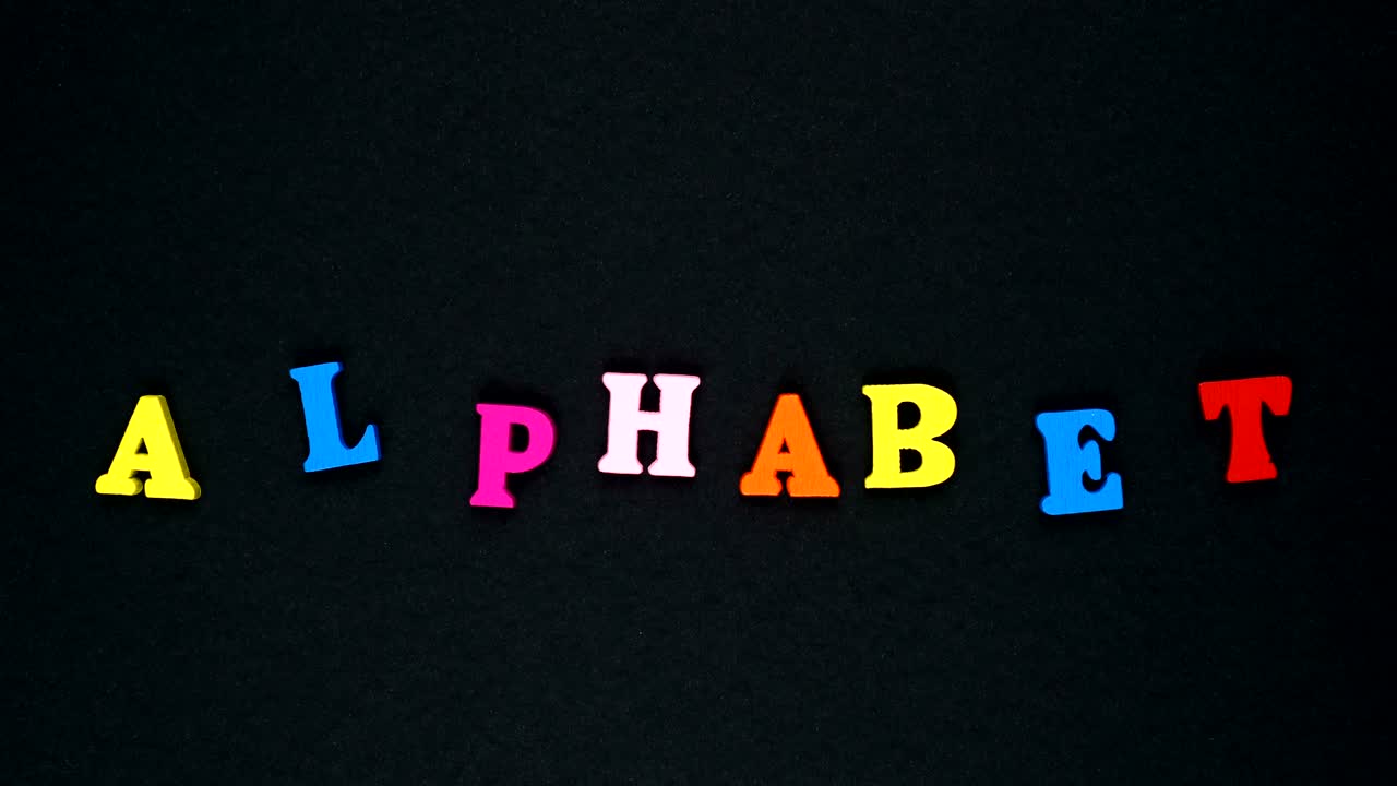 Word "alphabet" formed of wooden multicolored letters. Colorful words loop.