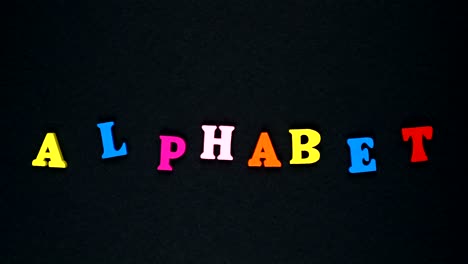 word "alphabet" formed of wooden multicolored letters. colorful words loop.