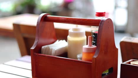 hand reaching for sauce in a wooden basket