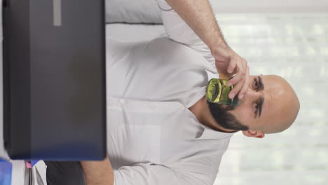 vertical video of home office worker man has tooth sensitivity.