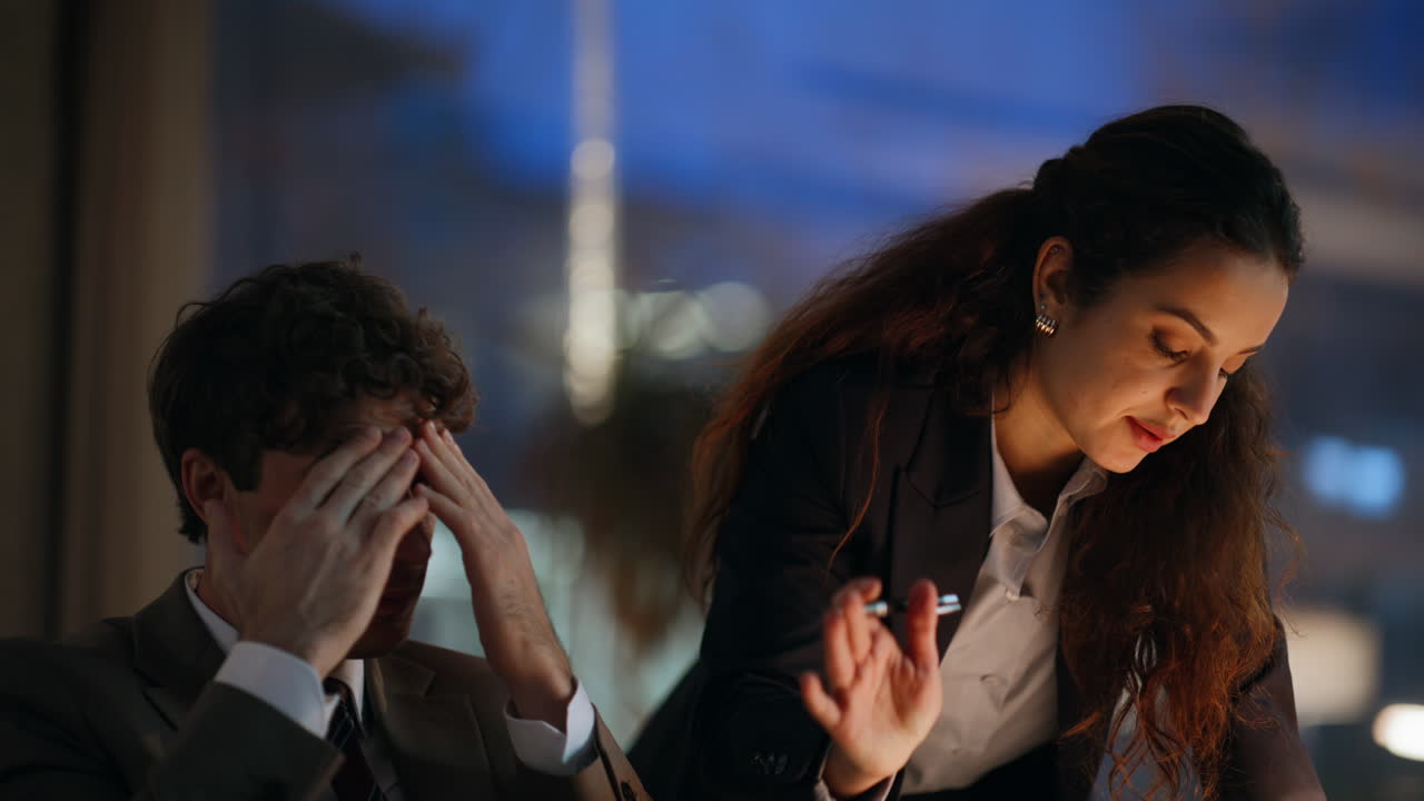 Two partners frustrated fail business closing laptop at night office closeup