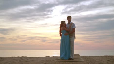 Couple-posing-on-beach-at-sunrise.-Pregnant-couple-standing-on-sea-beach