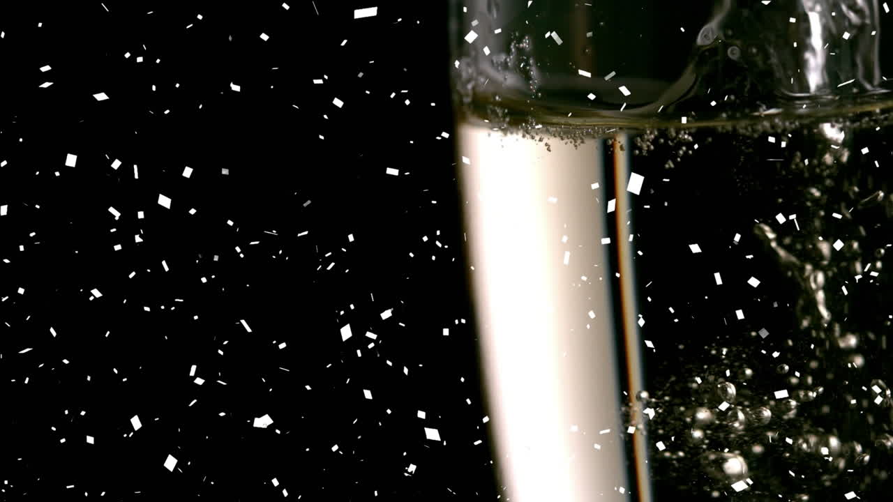 Animazione di coriandoli che cadono su un bicchiere di champagne