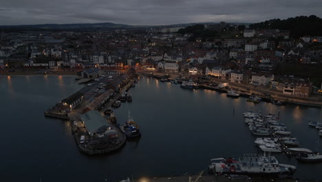 establishing night drone shot over scarborough harbour and town