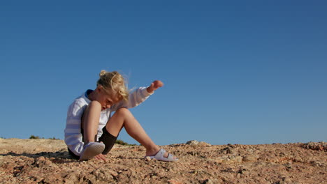 little girl playing on rocks outdoors