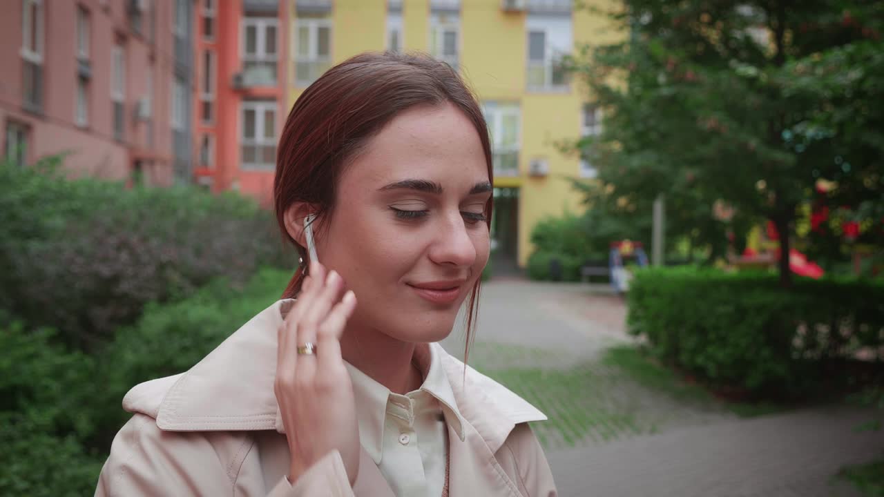 joven empleada con auriculares inalámbricos auriculares escuchando música en la ciudad