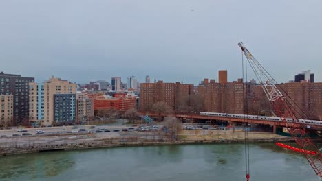 rising shot of crane in foreground, projects in harlem in new york city 4k drone