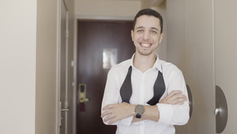 man waving in a hotel corridor