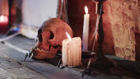 video of stack of books, frame with spider web, skull and candles on brick wall background