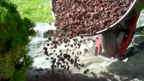 dumping lava rock onto ground in slow motion