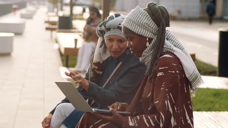 Muslimische-Frauen-Benutzen-Laptop-Im-Freien