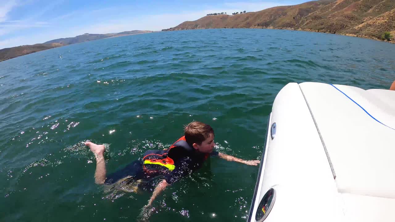 Boy Swimming in Lake with Life Vest