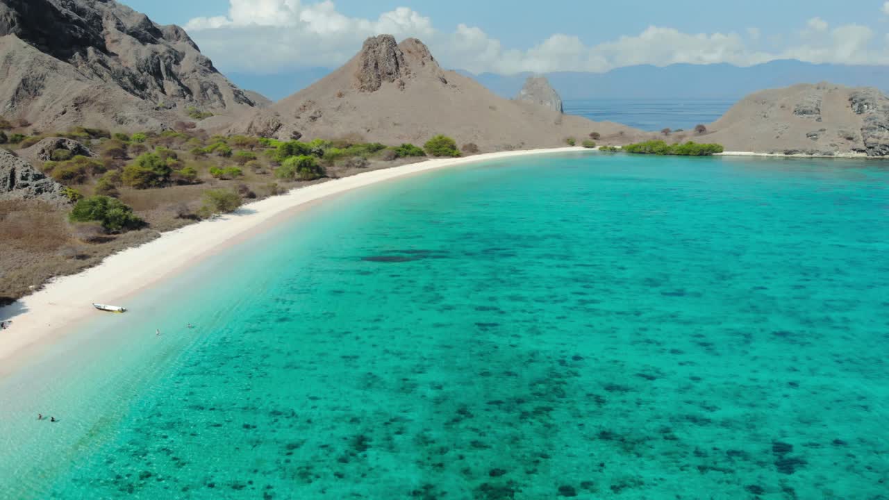 The Pink Beach and its turquoise water and steep Hills On Padar Island in Komodo National Park, Indonesia
