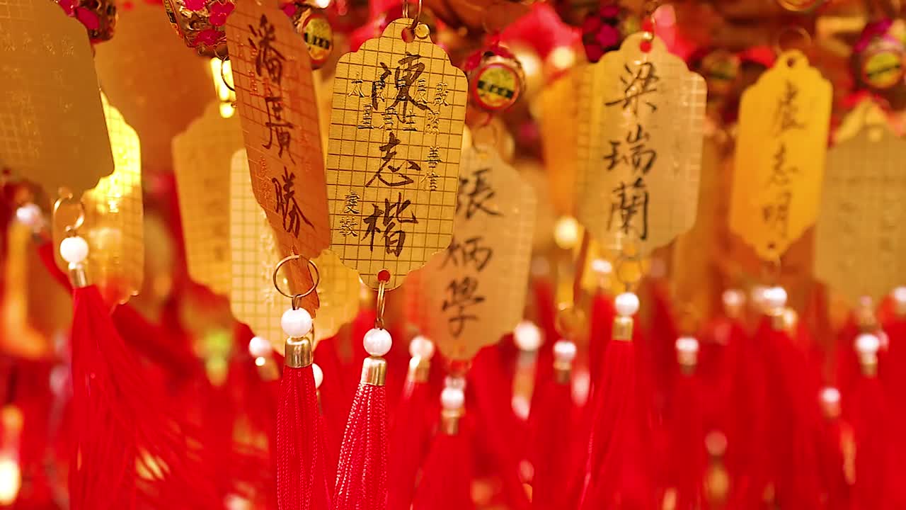 Close-up of golden tags adorned with red tassels, capturing intricate details and vibrant colors.