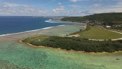 drone panning down over asan point and the coral of guam