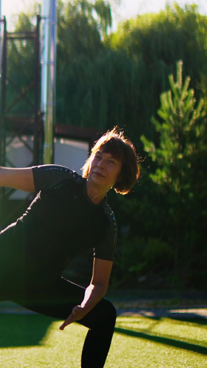 Donna matura che pratica yoga all'aperto in un giardino soleggiato