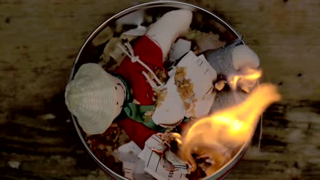 sorcery witchcraft voodoo ritual with a doll being thrown out inside a bowl with fire to make a curse spell with him.  muñeco de año viejo