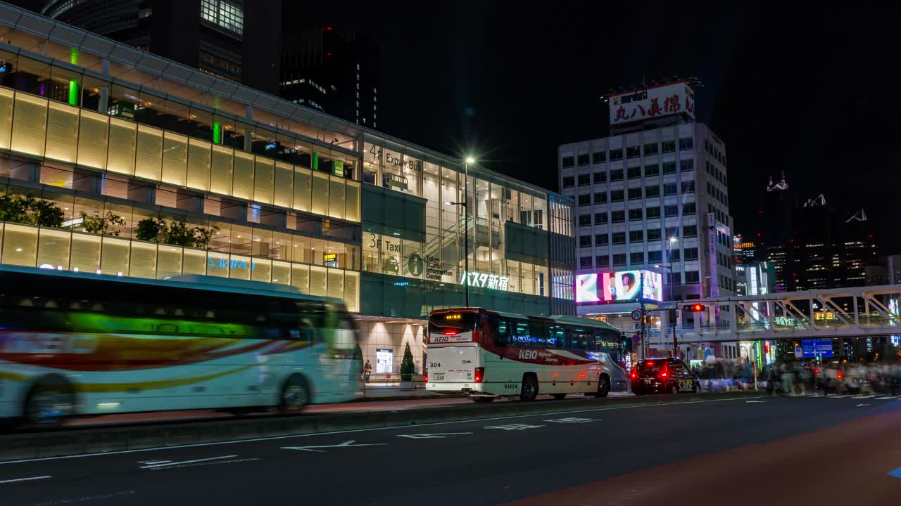 Shinjuku train station night time lapse, exterior view of station building over busy road