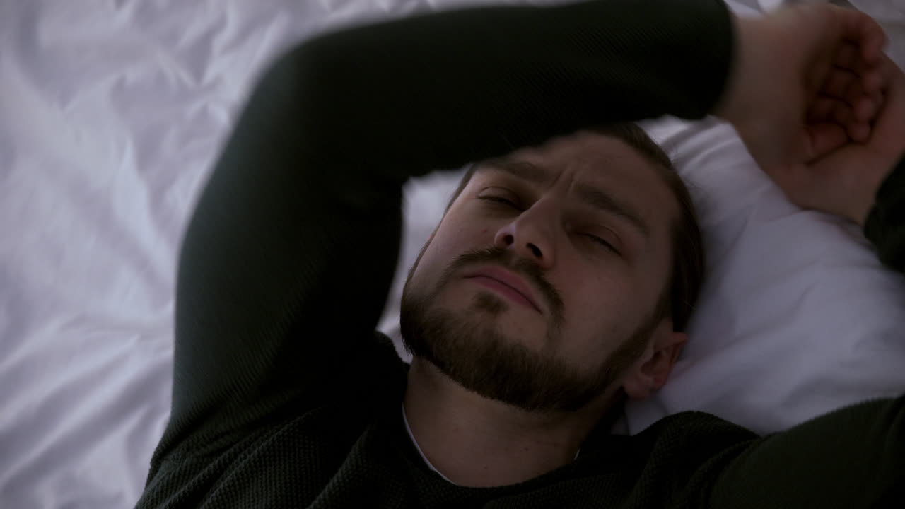 un joven tendido en la cama.